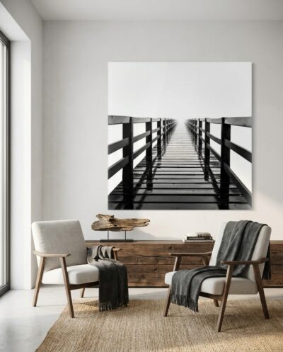 A weathered boardwalk runs dead straight into thick fog, its dark planks brightening until they dissolve into pure, glowing white.