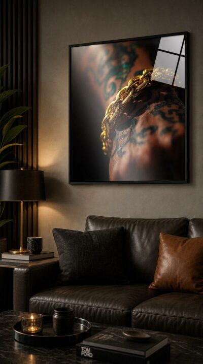 A tattooed forearm bears a massive gold chain, every link and inked line caught in a hard beam of stage light against deep shadow.
