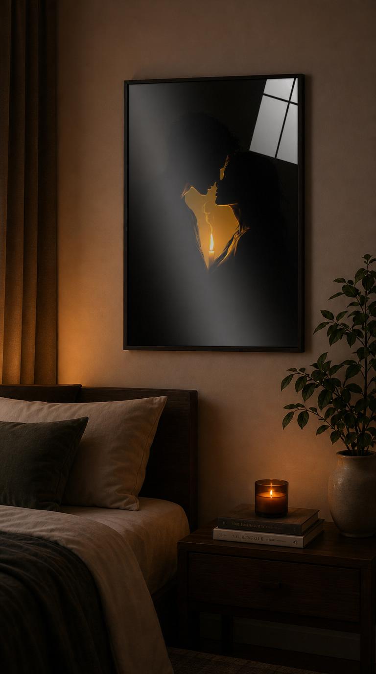 Two silhouettes lean toward one another across the warm glow of a single candle, their near-kiss carved out of pure darkness by a slender thread of light.