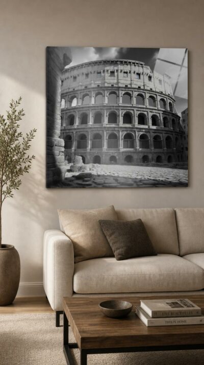 The great Roman amphitheater rises in silver and shadow, its tiered arches sweeping across a dramatic sky above a deserted cobbled forecourt.