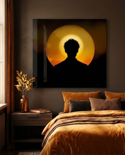 A figure seen from behind stands before a molten disc of light, its silhouette rimmed in gold as day dissolves into darkness.