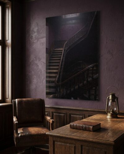 A grand old stairwell photographed from above, its dark banister curving down into plum shadow beneath a distant, cool skylight.