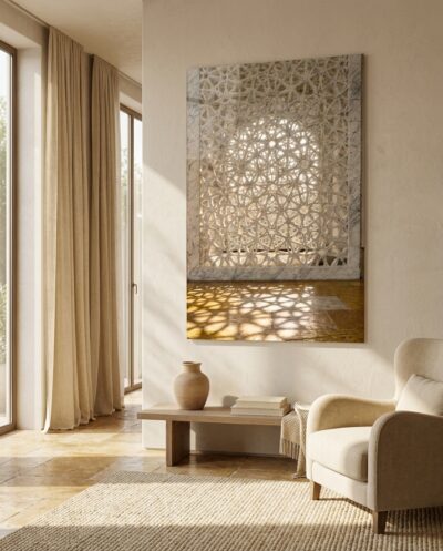 Daylight sifts through a pierced marble screen, laying its star-shaped geometry in soft gold across a warm stone floor.