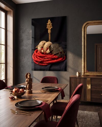 Coiled red coral, carved ivory bangles and a gilded staff gathered in warm still life against dark cloth.