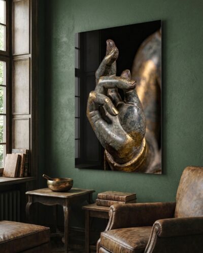 A stone hand lifts from darkness, thumb and finger meeting in the ancient gesture of teaching, its bronze gilding catching a warm, low light.