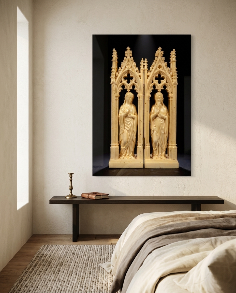 A carved ivory diptych of two robed figures rises through trefoil arches, glowing warm against deepest black.