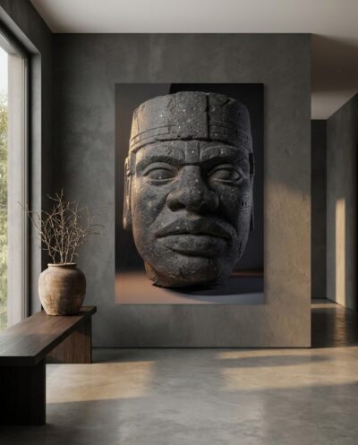 A colossal basalt head with a calm, weathered face, drawn from deep shadow by raking side light.
