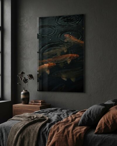 Concentric rings of falling rain scatter across copper carp gliding beneath a hushed, near-black surface.
