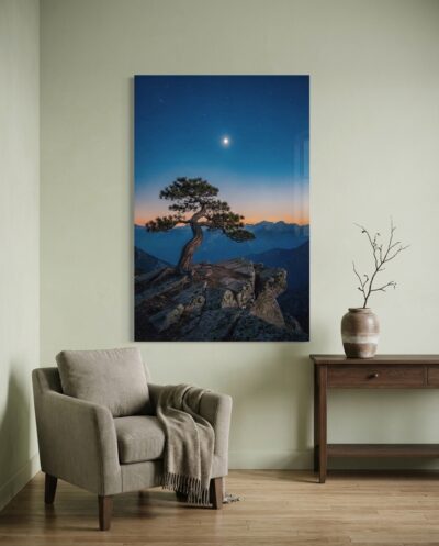 A solitary weathered pine stands sentinel on a granite precipice as twilight deepens and the evening star emerges over distant mountain ridges.