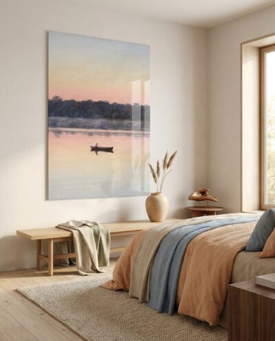 A solitary rowboat glides across mirror-like waters bathed in the soft rose and amber glow of daybreak.